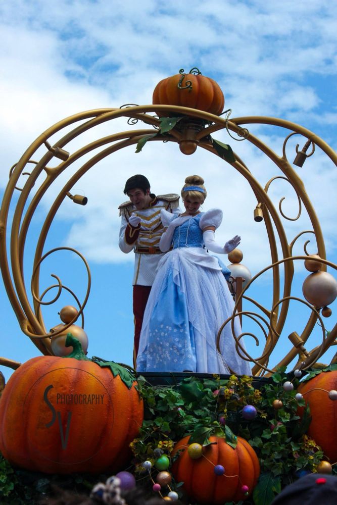 2013 Disneyworld parade of Cinderella and Prince Charming on top of their float that’s surrounded by pumpkins and the vines making the shape of the carriage around them. 