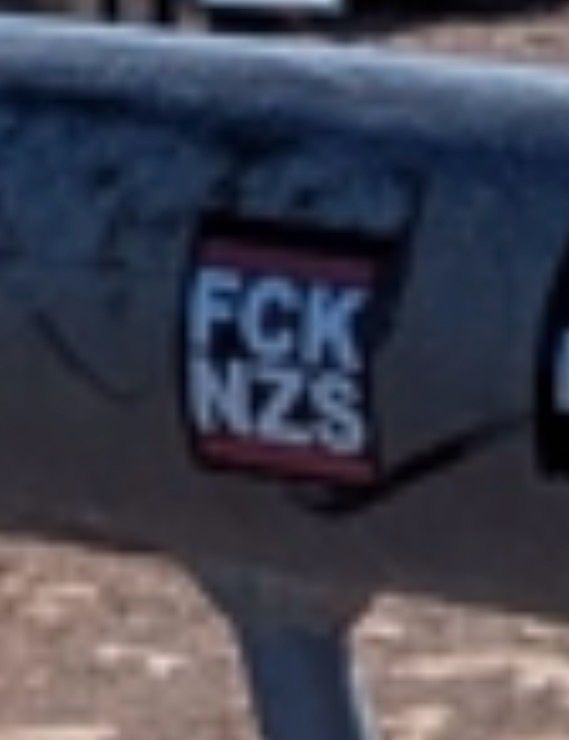 Aufkleber mit Aufschrift FCKNZS auf einem Geländer