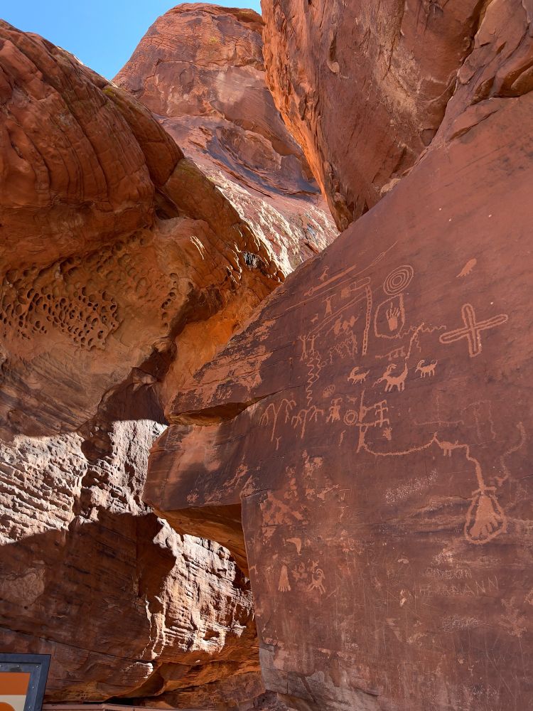 Photo of a rock formation with various drawings and markings from early native Americans.