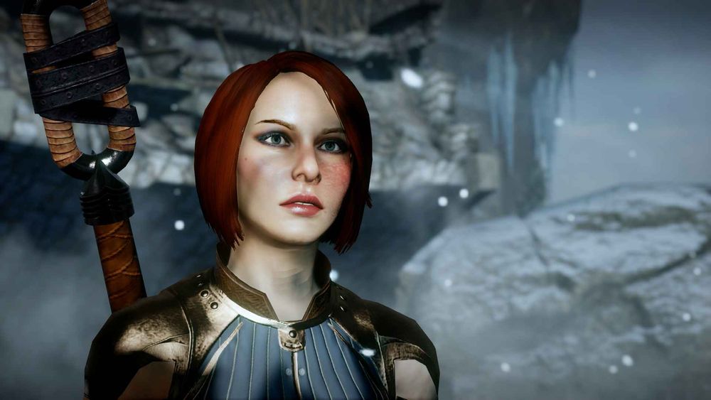 A female placer character with pale skin and a burn scar over the left side of her face. She has chin length red hair, wearing blue circle robes and carrying a staff.