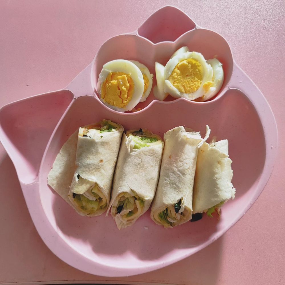 Wrap de vegetales y queso, cortado en cuatro trozos. También hay huevo cocido en otra de las separaciones de mi fabuloso plato rosa con forma de hello kitty.
Sobre la misma mesa