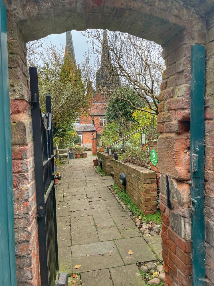 View through a gateway to Lichfield cathedral in the distance 