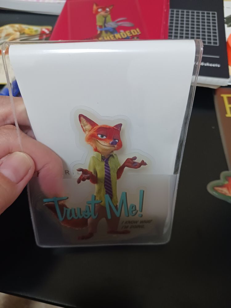 メモ帳のカバーにニックのダイカットステッカーが入っている、下部にTrust me I KNOW WHAT I'M DOING と書かれている