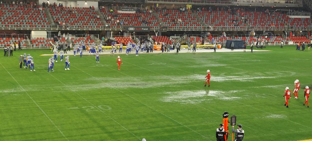 A wet Audi Field, with football players 