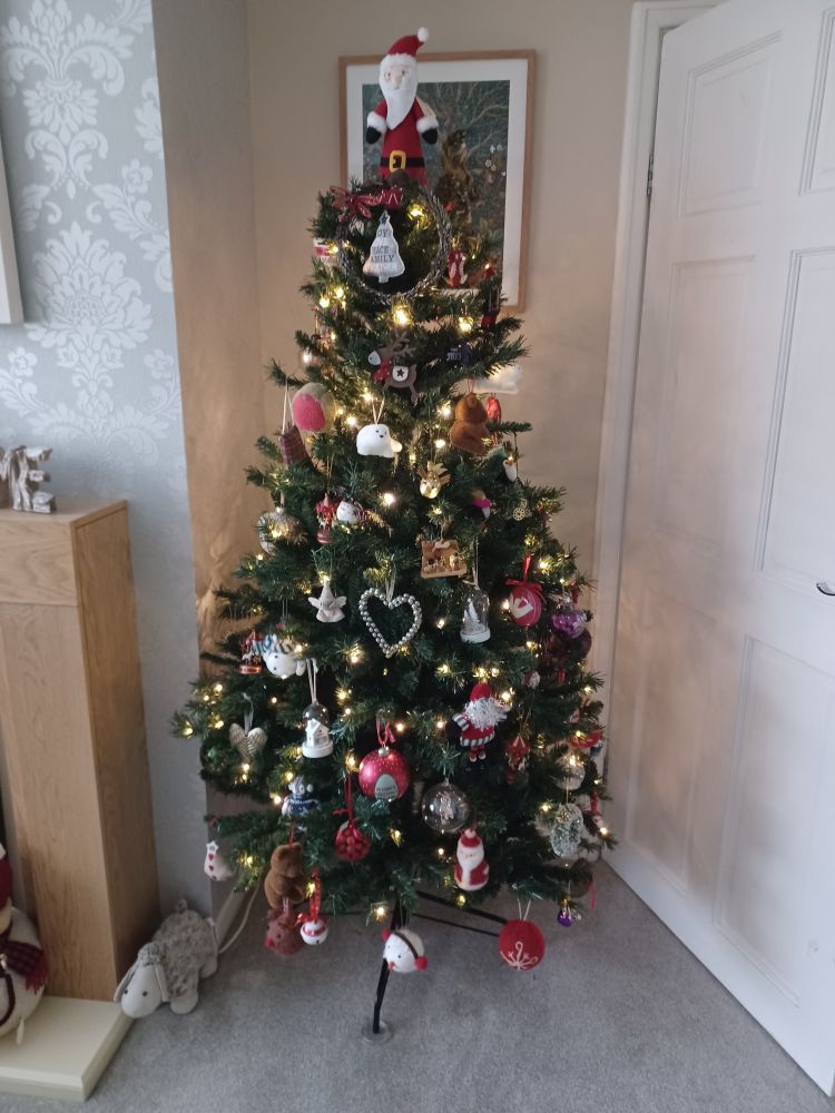 A fully decorated artificial Christmas tree in the front room. I definitely haven't used too many ornaments and made it look a bit tacky.