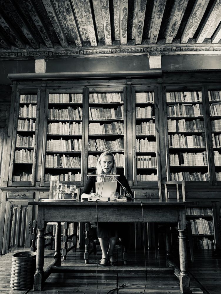 Black and white photo of me presenting my paper in the library taken by Lucie Boulay