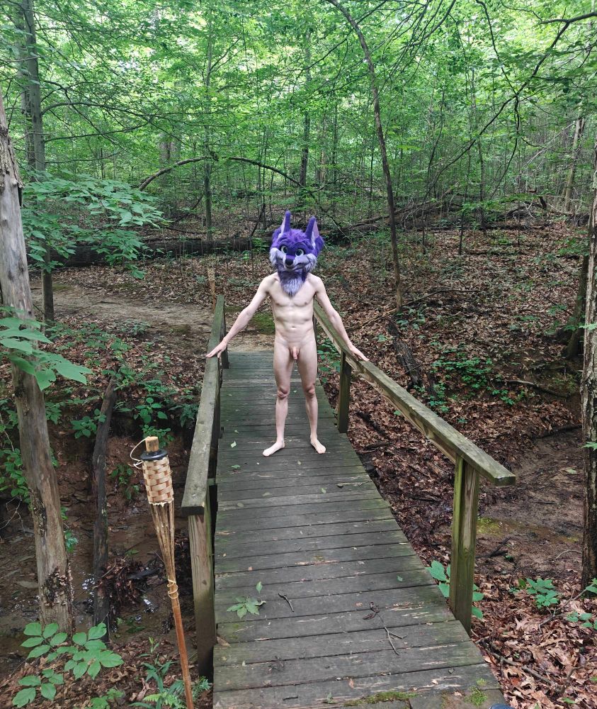 Standing in the middle of a bridge, nude