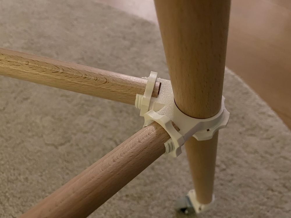 close up of a wooden joint where two small rods are attached to a large rod using a 3d printed connector