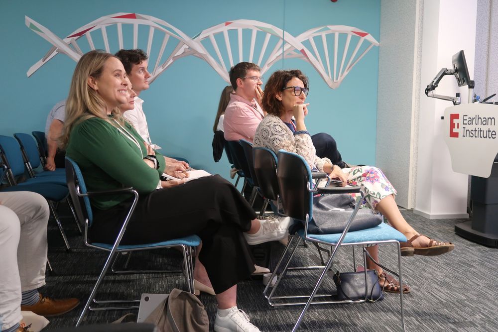 Attendees sitting in the conference room listening to one of the speakers who is not visible in the photo.