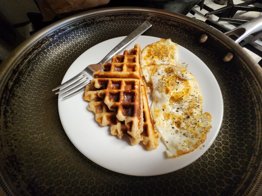 a plate with waffles and fried eggs
