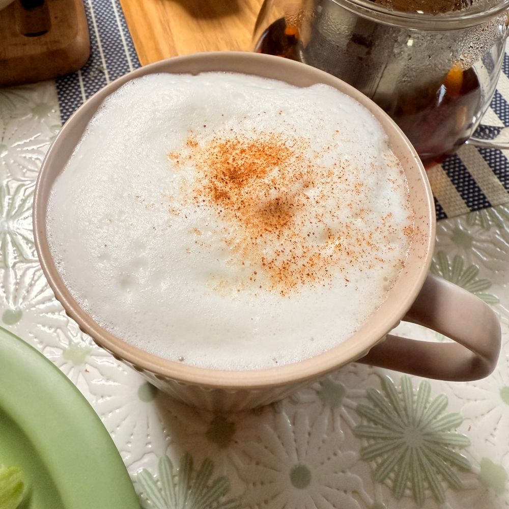 ティーラテ。泡立てた牛乳にシナモンパウダーが振ってある。