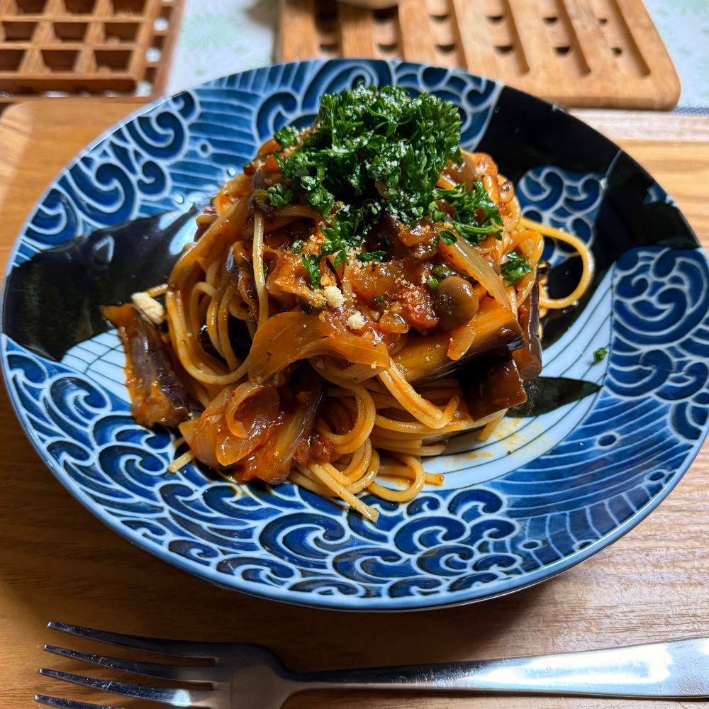 白波くじらの器に、ボロネーゼソースベースのナスと玉ねぎとしめじのパスタ。生のパセリと粉チーズを振っている。