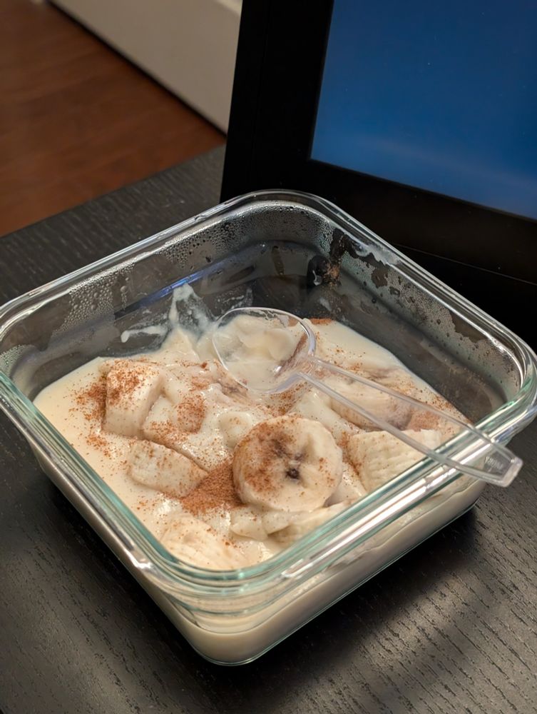 A glass bowl filled with banana pudding 
