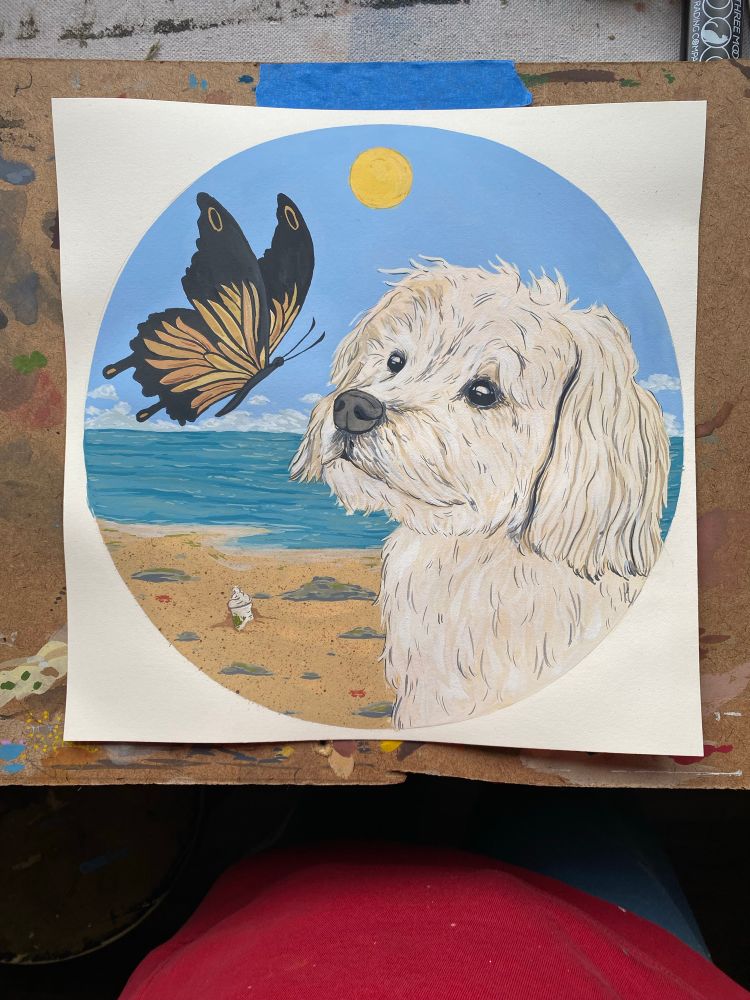 Little white dog on the beach staring at a butterfly. Very cute and adorable. Imagine soft ears in your hand.  