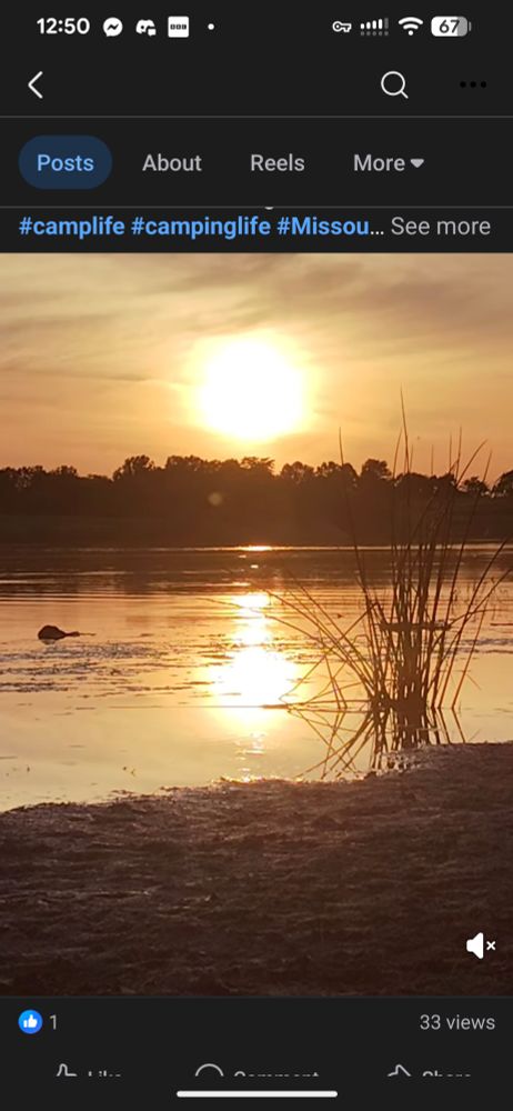 Screenshot of a beautiful video of sunset over a lake with reeds and a beach in the foreground