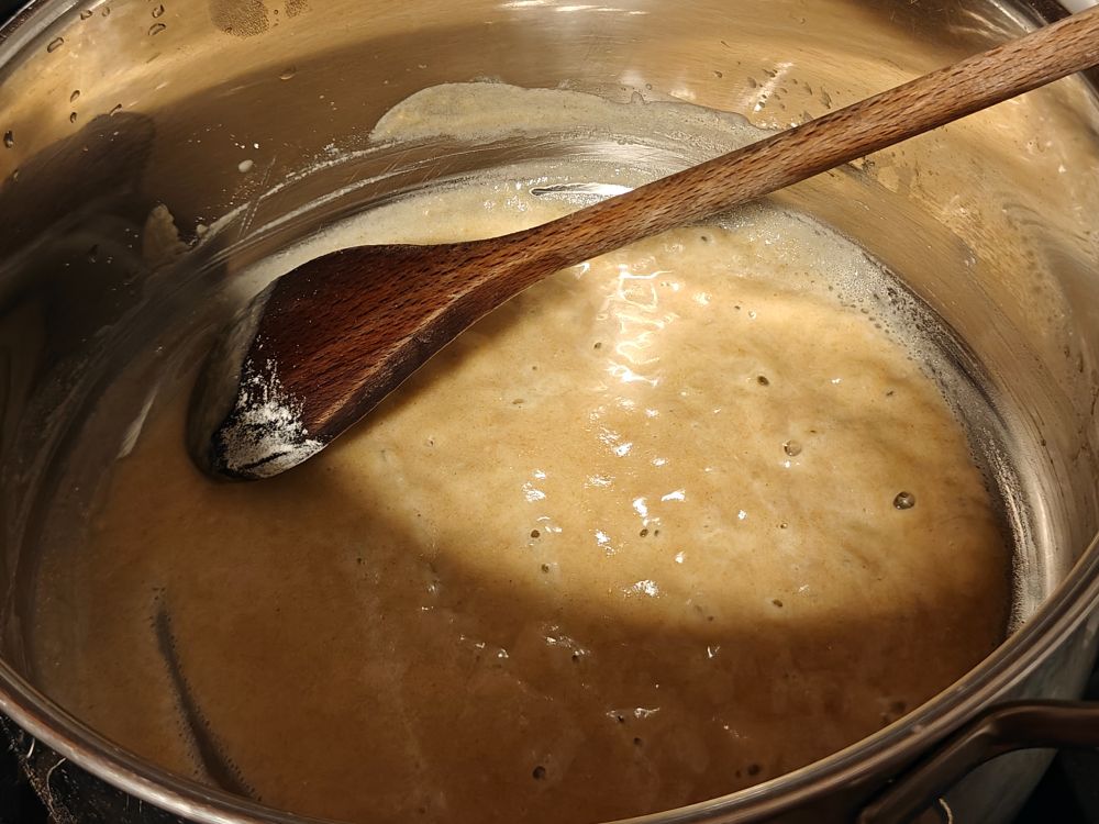A large stainless pot of bubbly roux