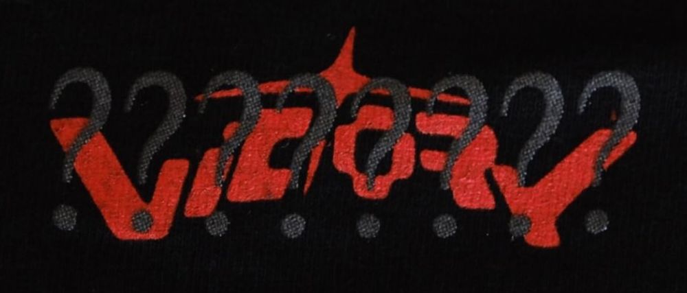 8 question marks in front of a stylized word "Victory", printed on a shirt.