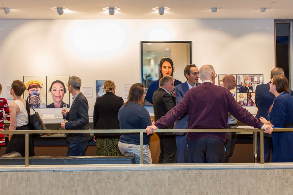 A view of the exhibition gallery full of visitors.