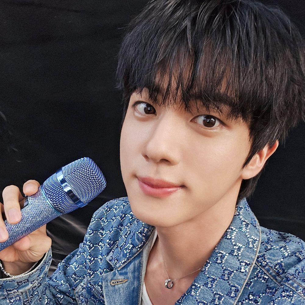 Jin concert photo with blue microphone and outfit