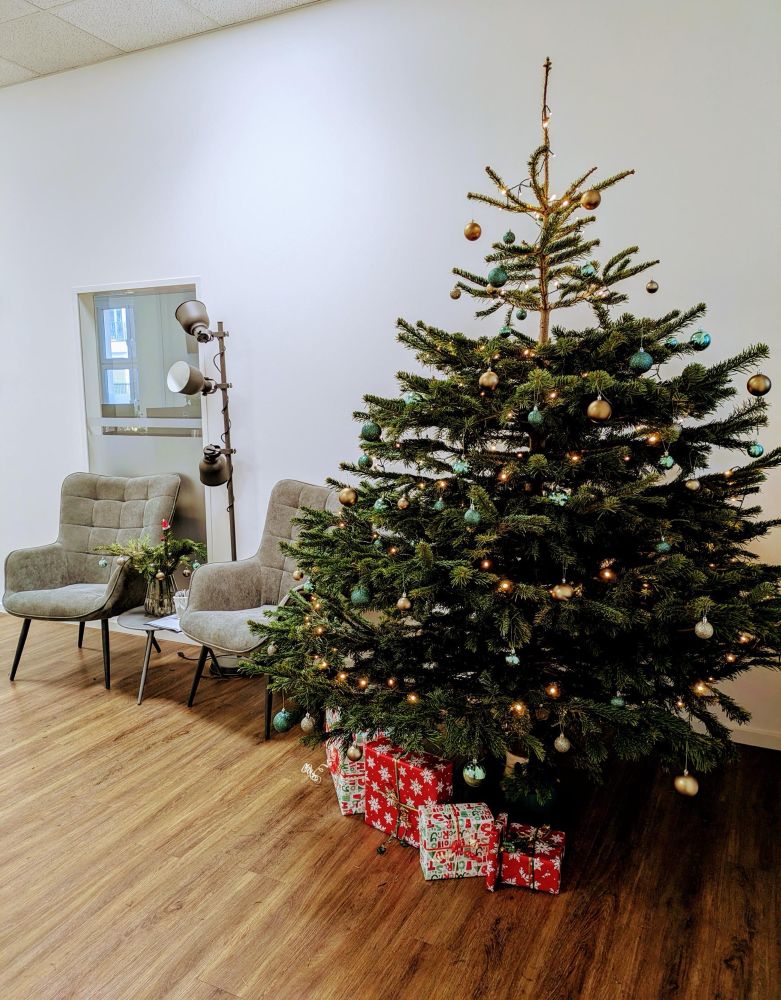 Ein geschmückter Weihnachtsbaum im Eingangsbereich eines Büros.