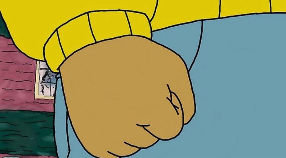 Arthur’s fist from the pbs kids show “Arthur”. His hand is brown and he’s wearing a yellow sweater and blue jeans. 