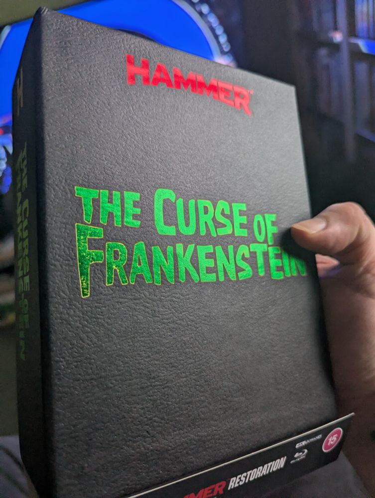 The actual contents of the package. Curse of Frankenstein 4K limited edition.titled embossed in green on the black external slipcase. Red Hammer logo above.