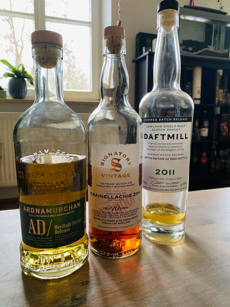 Drei Flaschen Single Malt (Spirits) auf dem Wohnzimmertisch.