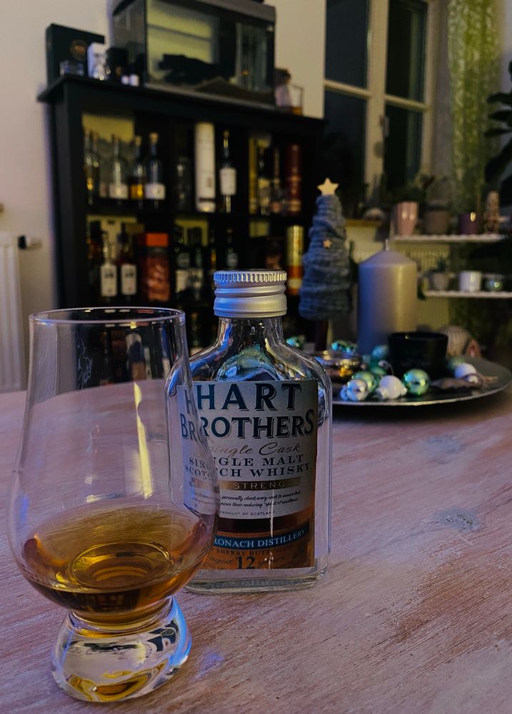 Ein Glas Whisky und eine kleine 10cl Sample Flasche Glendronach auf dem Wohnzimmertisch. 