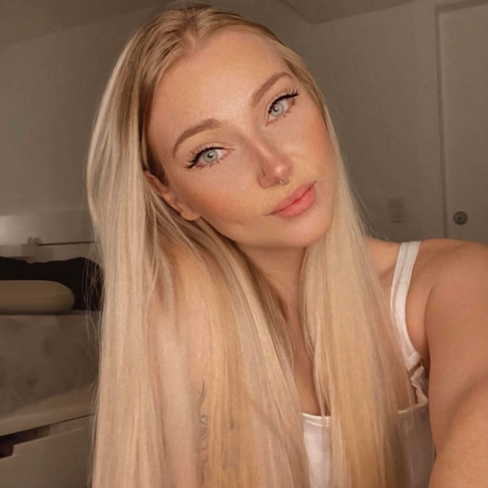 A close-up photo of a young woman with long blonde hair and light blue eyes.