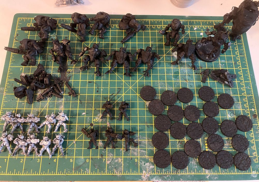 A bunch of miniatures, including a mix of sci fi infantry and battle suits primed and ready to paint.