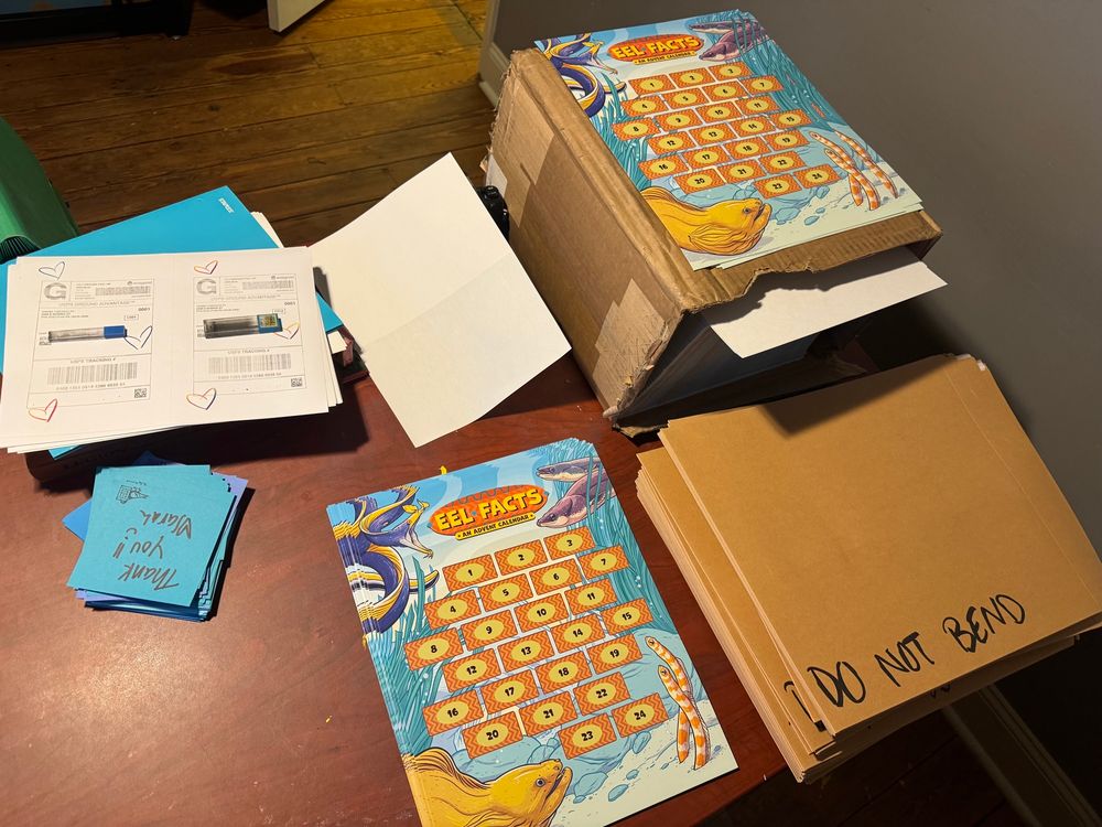 Sarah’s desk is a shipping station for advent calendars which have brightly colored eels all over them 