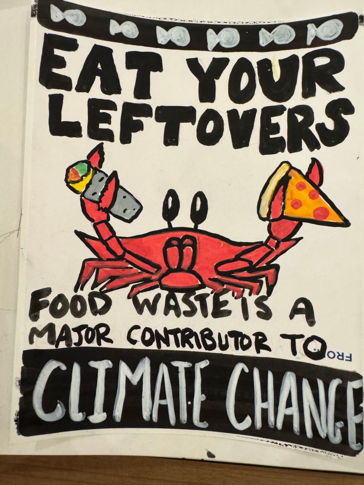 A sticker that has a crab holding both a burrito and slice of pepperoni pizza with the words eat your leftovers good waste is a major contributor to climate change 