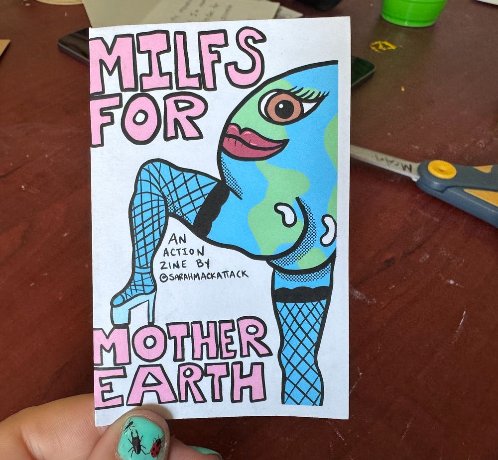 caked up mother earth in her thigh high fishnets is stomping in her stripper heels looking back at it. The words say "Milfs for Mother Earth
