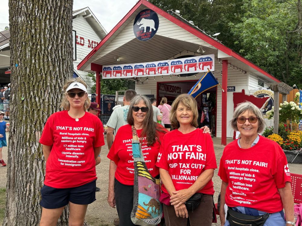 Volunteers in red shirts that say That’s Not Fair! GOP Tax Cuts for Millionaires.