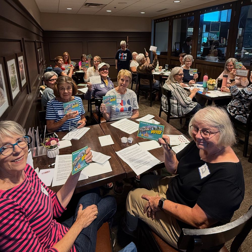 Room full of volunteers writing postcards to Mn state reps to ban assault weapons and to low info voters in PA and VA. 