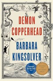 Book cover of Demon Copperhead by Barbara Kingsolver, featuring a vintage-inspired design with intricate black-and-white illustrations of a snake, a fish, a bird, leaves, flowers, a key, and a spool of thread. A small human figure in silhouette appears climbing or suspended in the background. The title is displayed in bold red and blue text, and the cover highlights its selection as an Oprah's Book Club pick and other accolades.