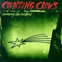 Album art for Counting Crows “Recovering the Satellites”. Album cover is deep green with a shooting six pointed star made of a light frame