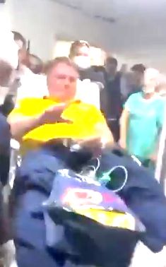 bolsonaro todo fudido numa maca com a cara vermelha toda horrivel levanta a mão nojenta pra acenar ao povo que celebrava mais uma internação do nosso futuro presidiário