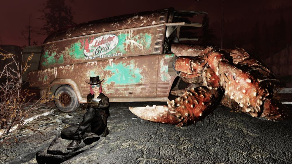 Image from Fallout 76

A red haired, black clad female ghoul sitting on a road, behind her is a slain hermit crab, it's "shell" the wreckage on an old delivery vehicle