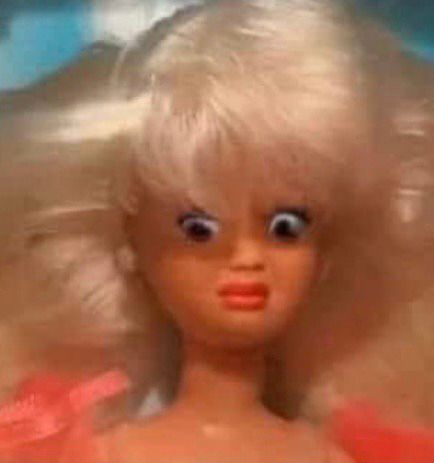 A Barbie-style doll with a disturbed expression on her face 