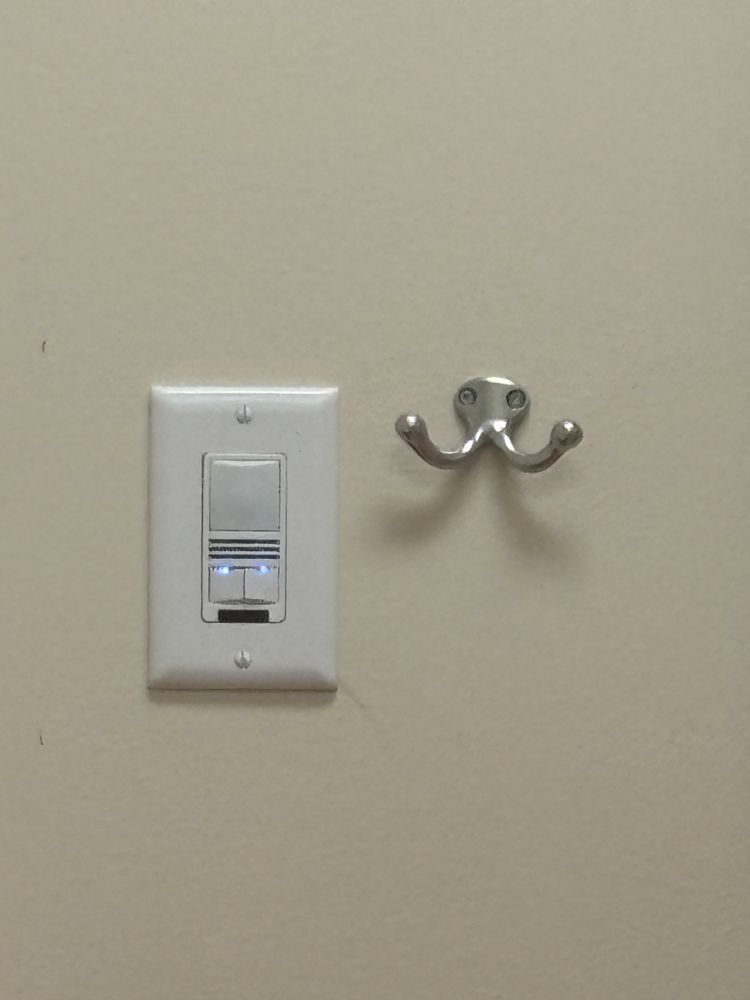 A coat hook by an outlet. 