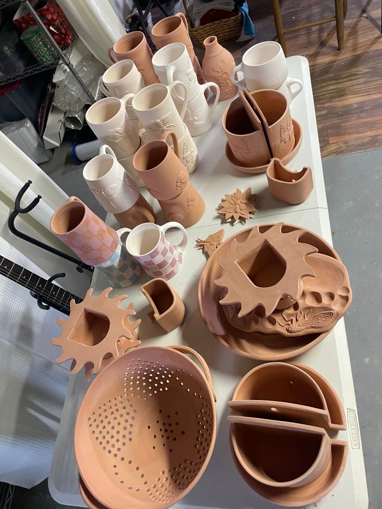 An assortment of unglaze ceramic pots on a table 
