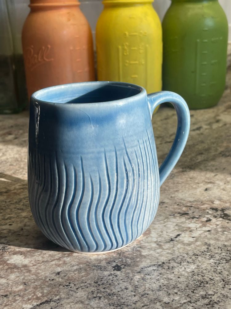 Light blue mug with carved wavy lines