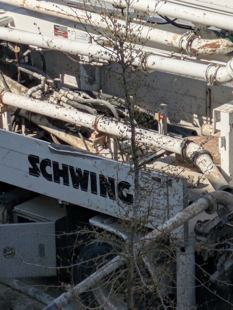 Picture of the side of a cement truck with "Schwing" on the side.