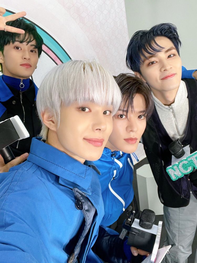 Jungwoo taking a selfie with Mark, Yuta, and Xiaojun during a content filming for NCT 2021. 