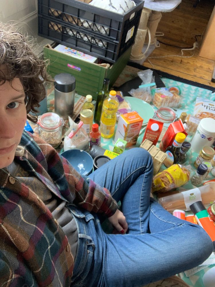 selfie van mij op de vloer in kleermakerszit, omringd door allemaal keukenspullen