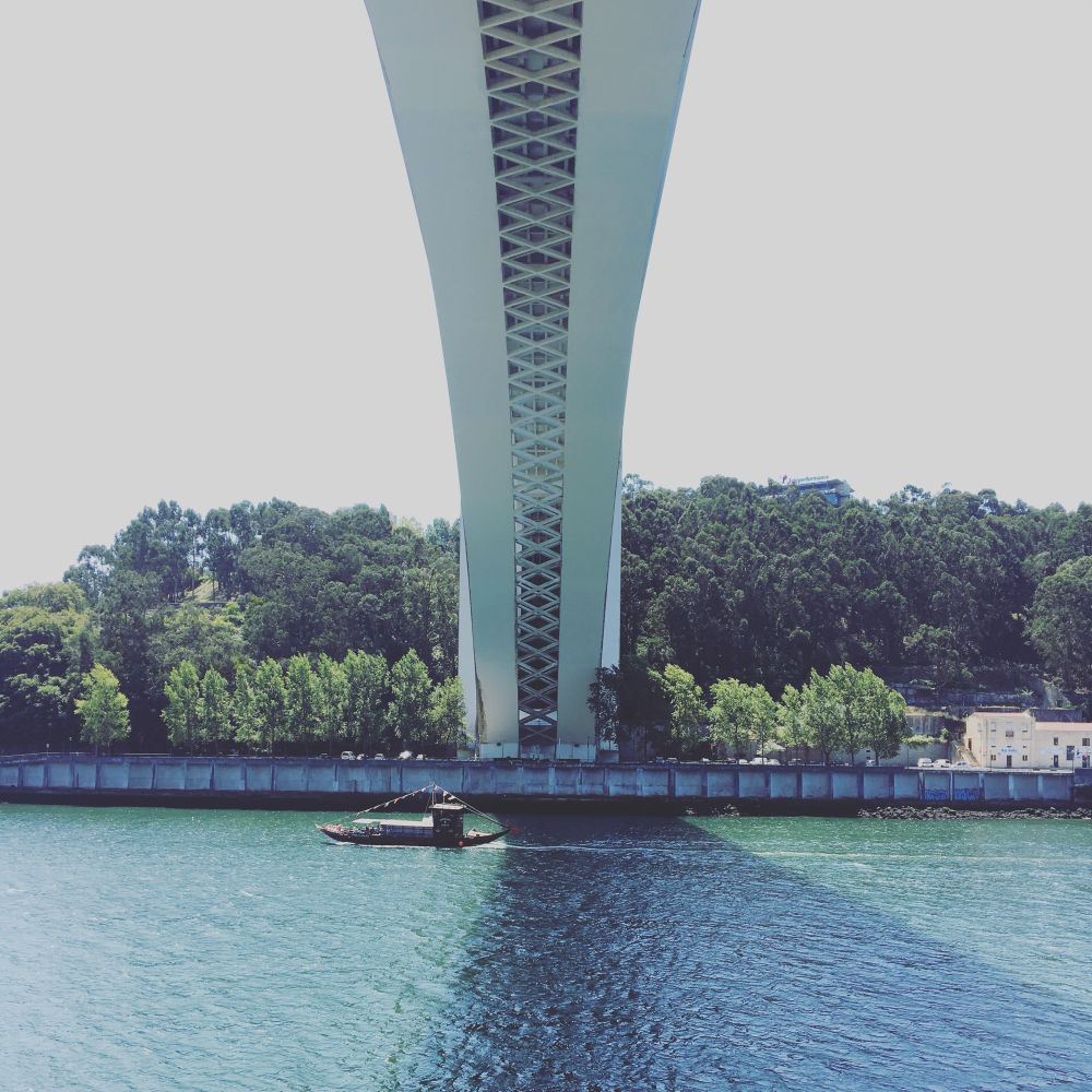 Sous une arche de pont à Porto. Un bateau sur le fleuve.