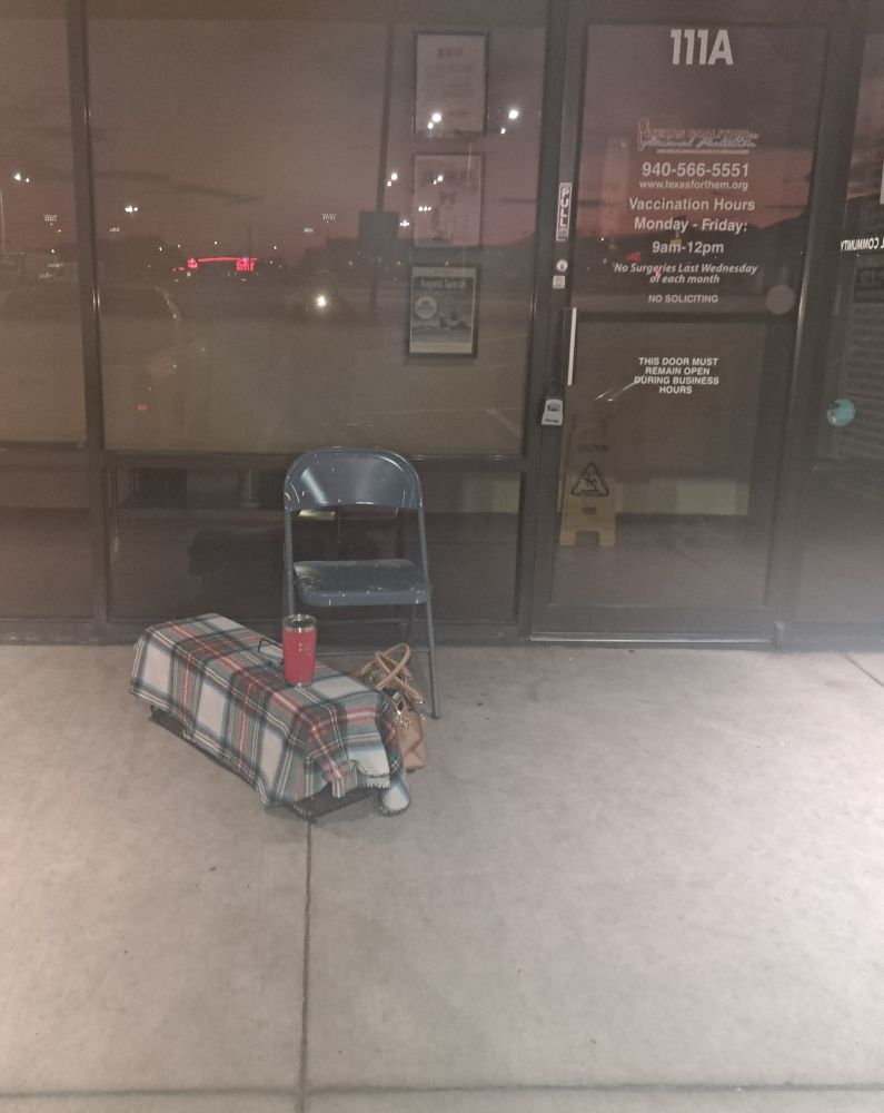 Coffee, folding chair, cat in covered humane trap and first in line.