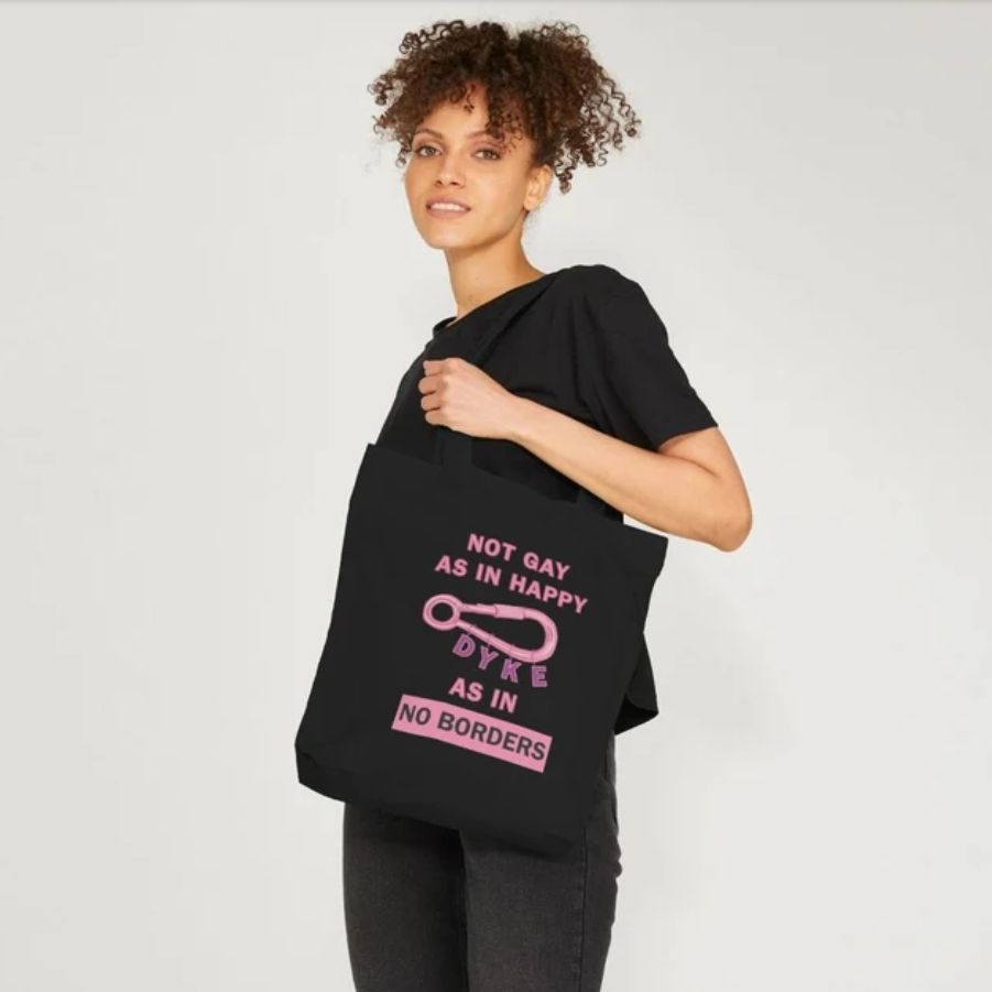 Pink Text on Black Tote Bag reads: Not Gay as In Happy Dyke As In No Borders