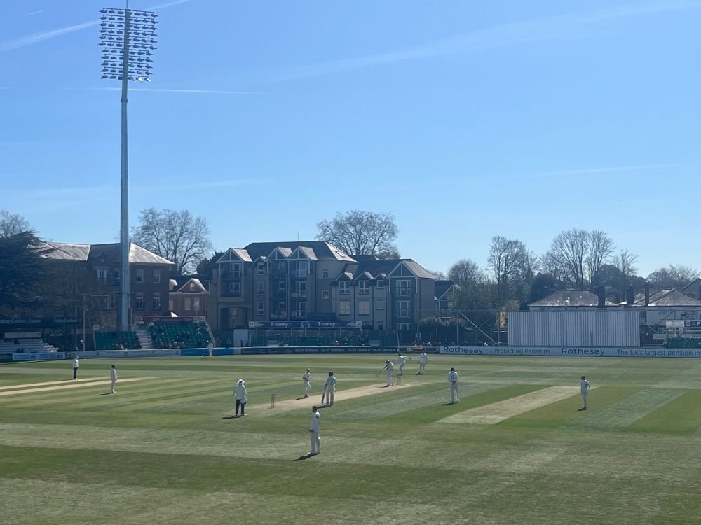 Blue skies over a game of red ball cricket at Essex county cricket club, Chelmsford. 